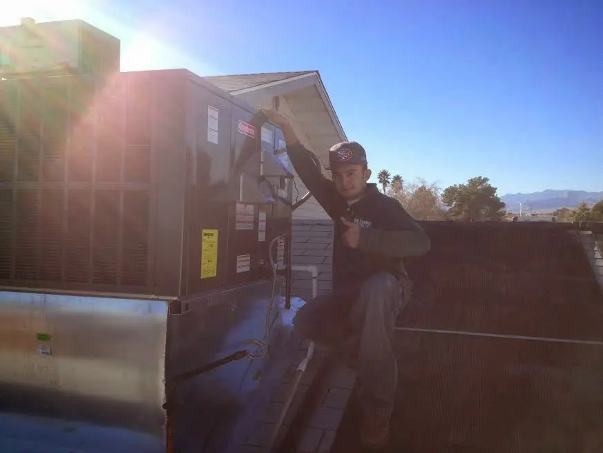 HVAC technician performing Heat Pump Repair on a rooftop unit in Gypsum